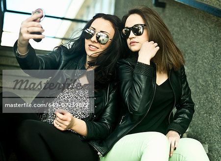 Two young woman making self portrait on mobile phone
