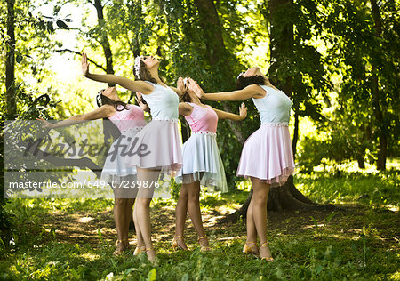 Four young ballet dancers performing in woods