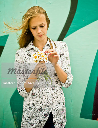 Portrait of young woman with bunch of daisies