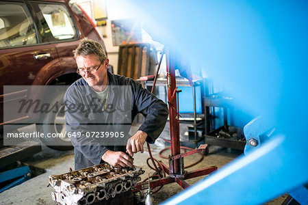 Mechanic working on car parts in garage Mechanic working on car parts in garage