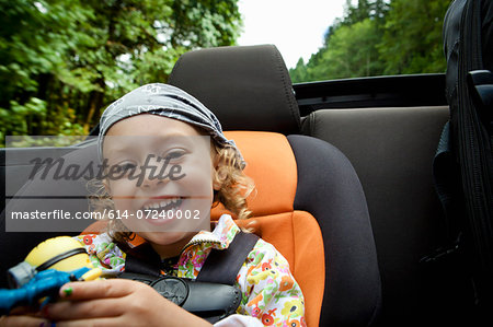 Portrait of female toddler in back seat of open soft top