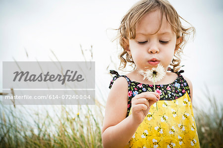 Portrait of female toddler with dandelion clock