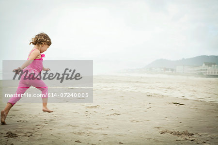Female toddler running on beach Female toddler running on beach