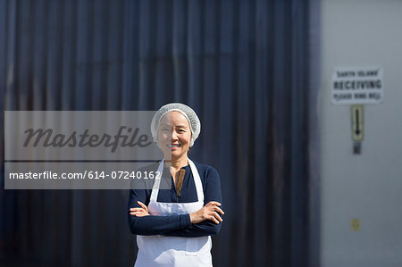 Portrait of female factory worker, arms folded