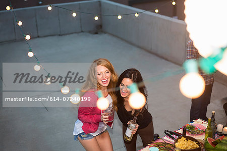 Two female friends dancing at rooftop party