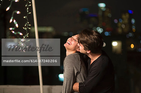 Young couple embracing at rooftop party