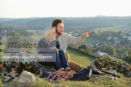 Father and son sitting on a rock with climbing equipment