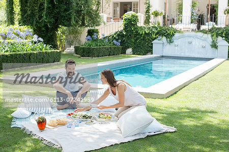 Couple enjoying picnic by pool