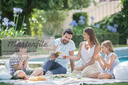 Family enjoying picnic at poolside