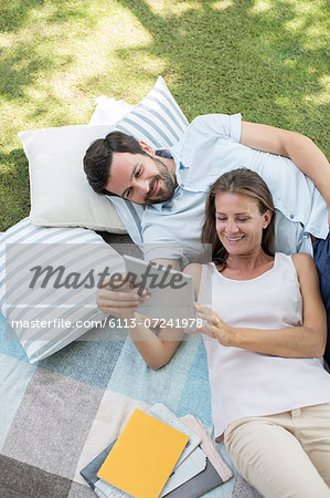 Couple using digital tablet outdoors