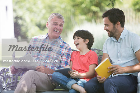 Multi-generation men laughing on bench