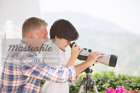 Grandfather and grandson using telescope