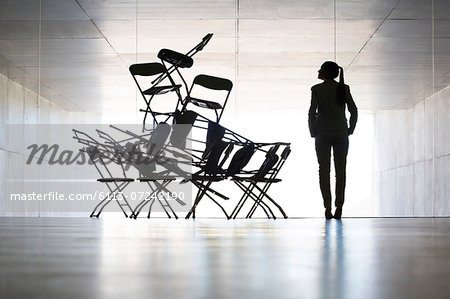 Businesswoman examining office chair installation art