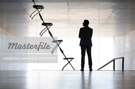 Businessman examining office chair installation art