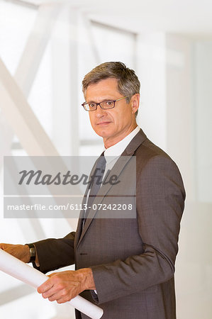 Architect holding blueprints in office