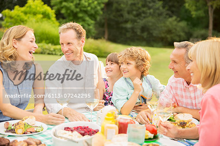 Multi-generation family enjoying lunch in backyard