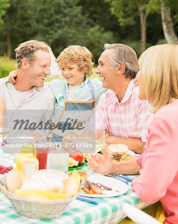 Family enjoying lunch at table in backyard