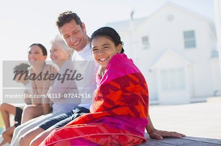 Multi-generation family sitting outside beach house