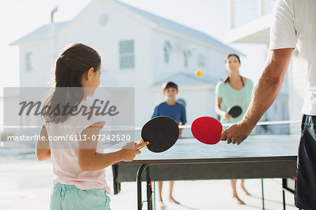 Family playing table tennis together outdoors