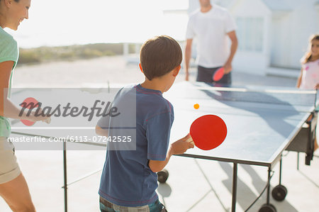 Family playing table tennis together outdoors