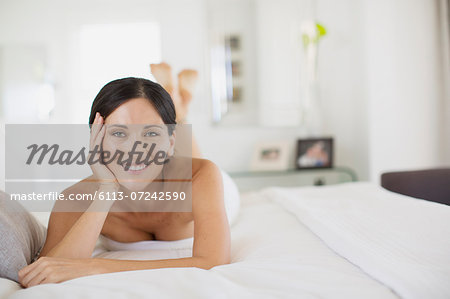 Smiling woman laying on bed