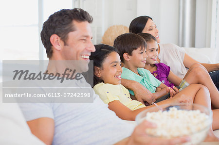 Family watching TV on sofa