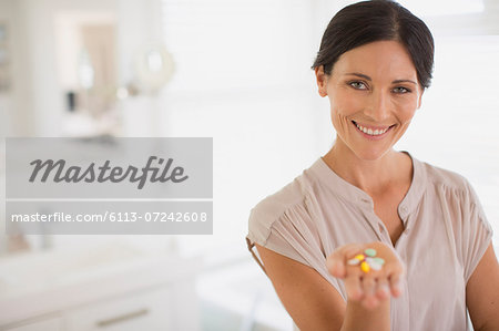 Woman holding handful of pills