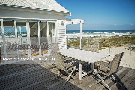 Table and chairs on balcony overlooking beach