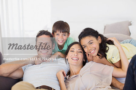 Family smiling together on sofa in living room