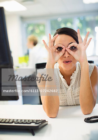Businesswoman making a face at desk in office