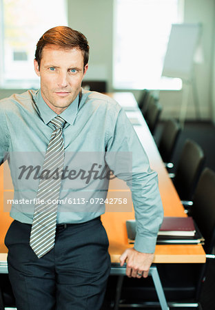 Businessman sitting at edge of conference table