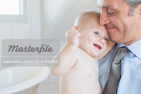 Father holding baby in bathroom