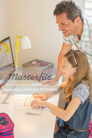 Father and daughter using computer together