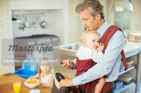 Father with baby packing bag for work