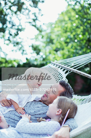 Father and children relaxing in hammock