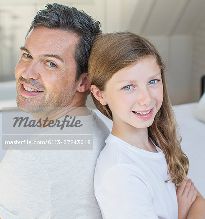 Father and daughter smiling in bedroom