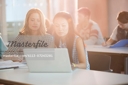 University students using laptop in classroom University students using laptop in classroom