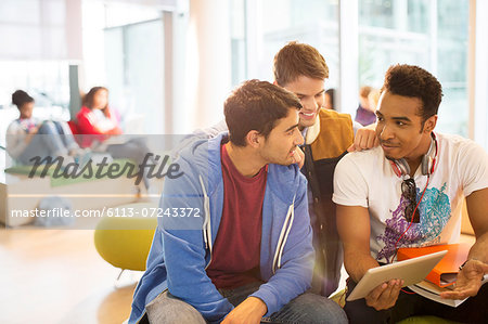 University students using digital tablet in lounge University students using digital tablet in lounge