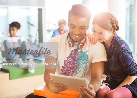 University students using digital tablet in lounge