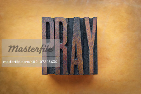 The word PRAY written in vintage letterpress type.