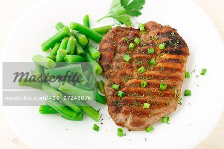 Delicious beef steak with green beans on a plate