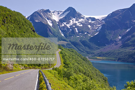 Coastal road in Norway leading to Bodo with snowy mountains of Saltfjellet-Svartisen National Park in the background