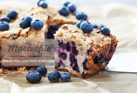 Piece of homemade blueberry cake with berries around, close up