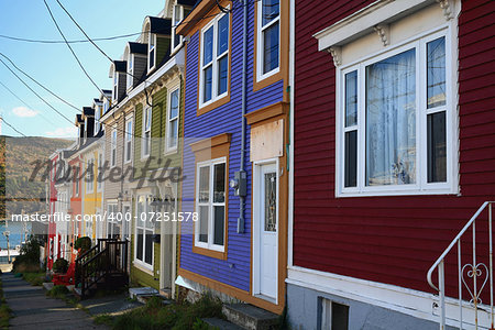 Front of typical for St. John's Newfoundland downtown houses very colorful, organized over very small area, narrow, Tall, with very small relaxing space and garden.