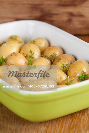 Baby potatoes with thyme, olive oil and salt on baking sheet