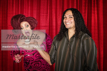 Smiling latino man with hungry drag queen and cupcake