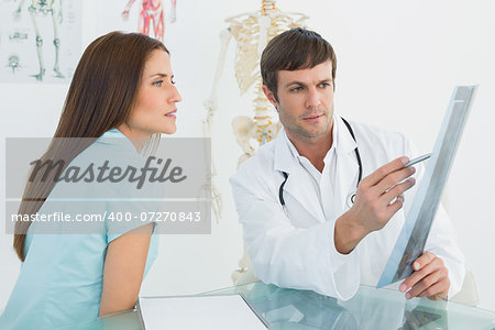 Side view of a male doctor explaining x-ray to female patient in the medical office
