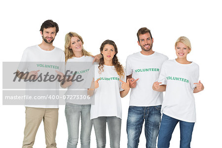 Group portrait of happy volunteers pointing to themselves over white background