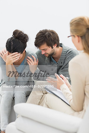 Displeased young couple in meeting with a financial adviser at home