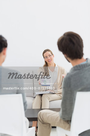 Female financial adviser in meeting with young couple at home